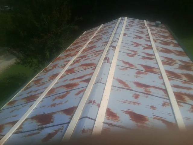 Rusted metal roof panels with new wood purlins before replacement — Storm Damage Roof Repair in Foothill Ranch by Roofing Brothers
